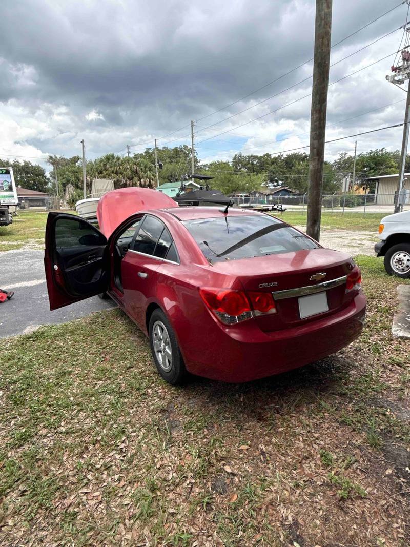Rear of the red 2014 Chevrolet Cruze available for weekly rental in Orlando, Florida